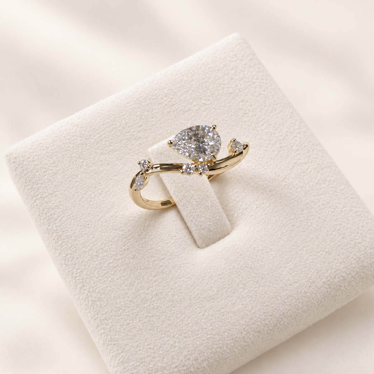 Arden Flame yellow gold pear diamond ring, angled front view on ivory