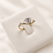 Arden Flame yellow gold pear diamond ring, angled front view on ivory
