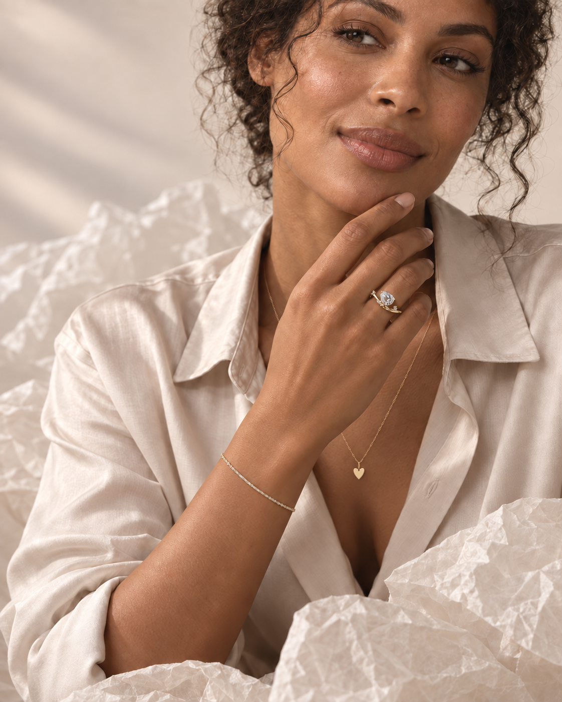 AI-assisted styling: Arden Flame ring on a model in a beige silk shirt, with fine bracelet and heart necklace; supporting jewellery sold separately.