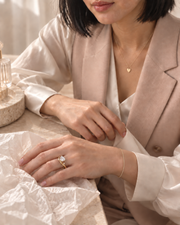 AI-assisted styling: Arden Flame ring on a model in a soft blush waistcoat with textured ivory tissue, fine bracelet and heart necklace; supporting jewellery sold separately.