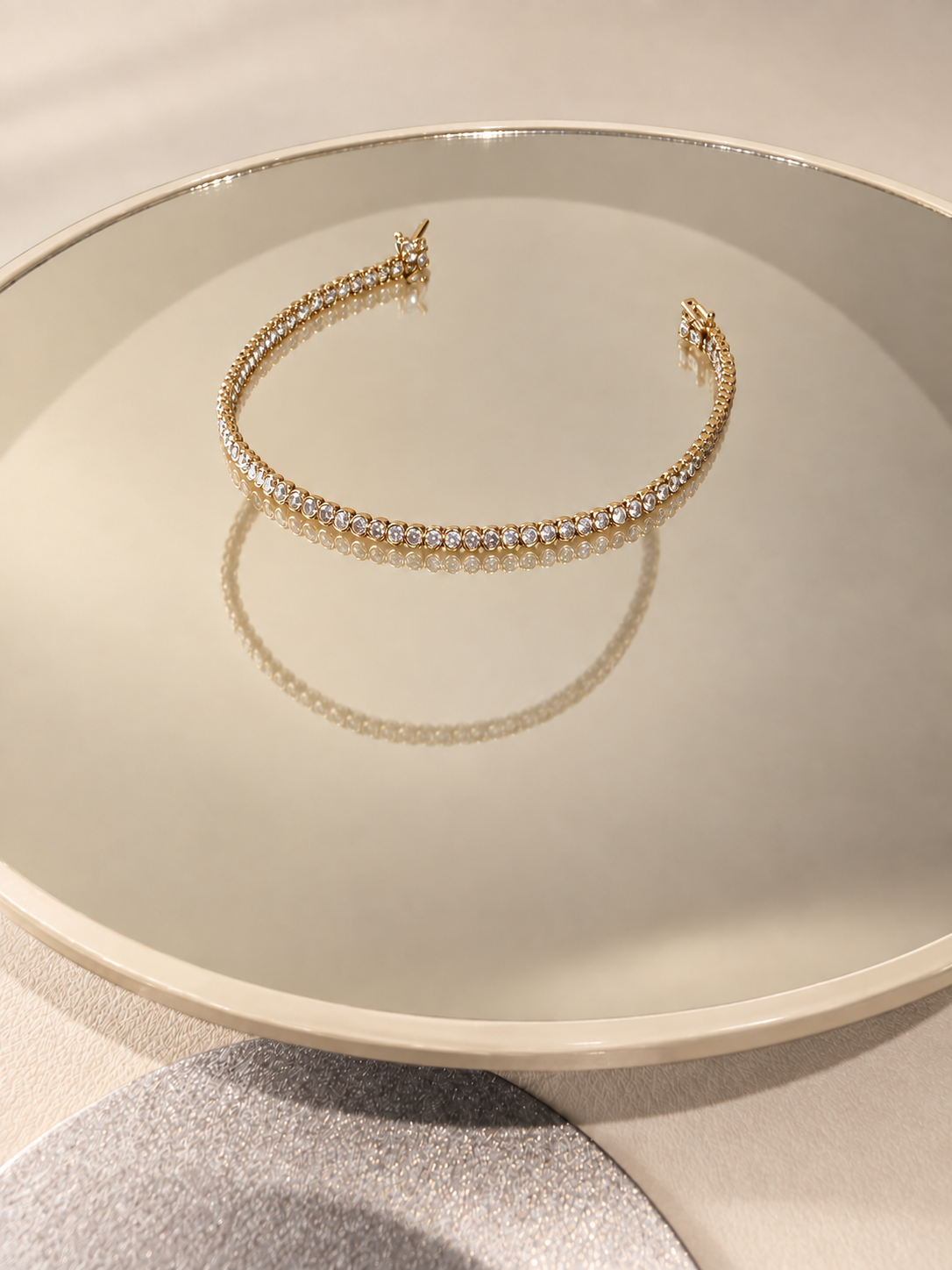 Sola Promise yellow-gold bezel diamond bracelet on a warm ivory-rimmed mirror