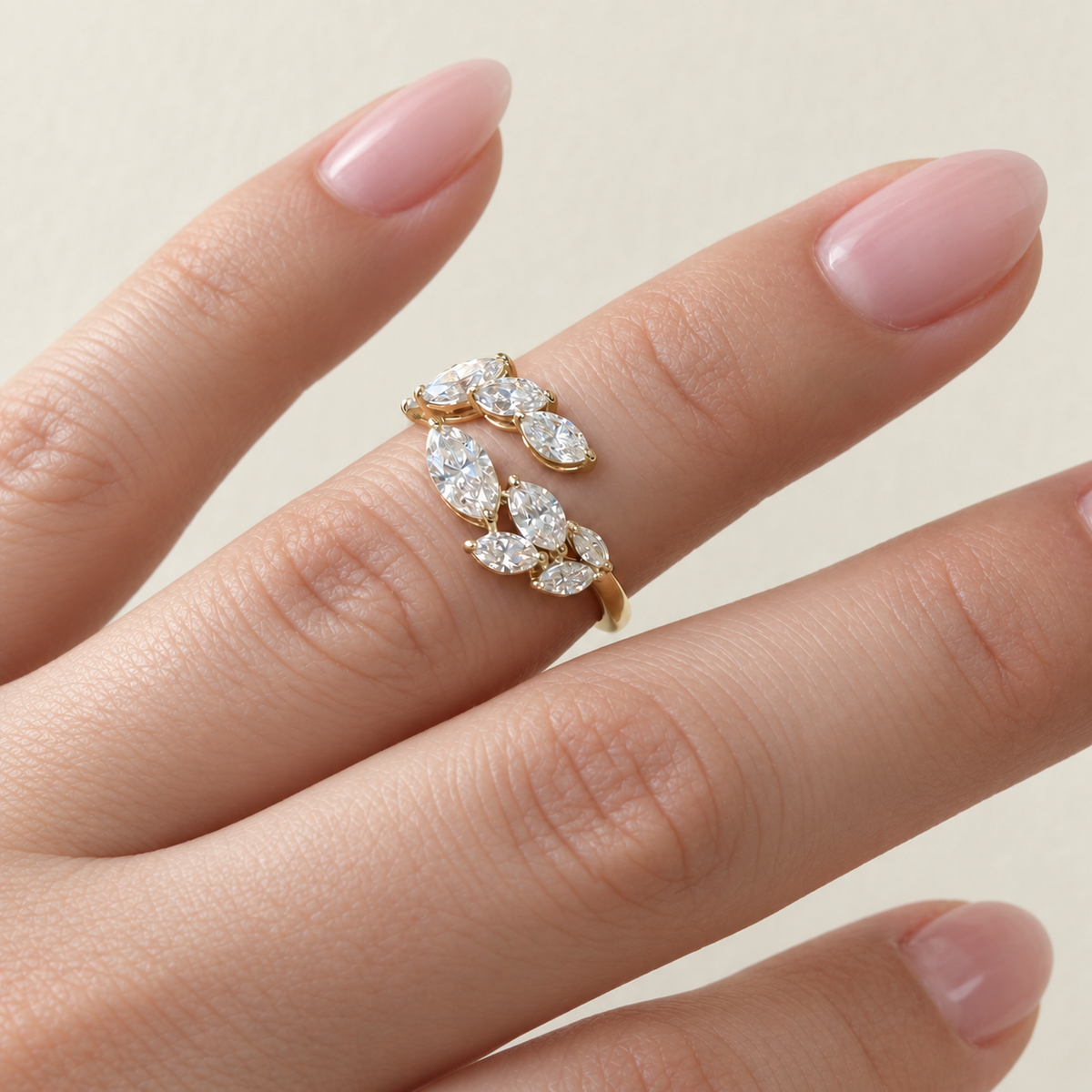 Laurel diamond leaf ring worn on a fair hand with a soft pink manicure
