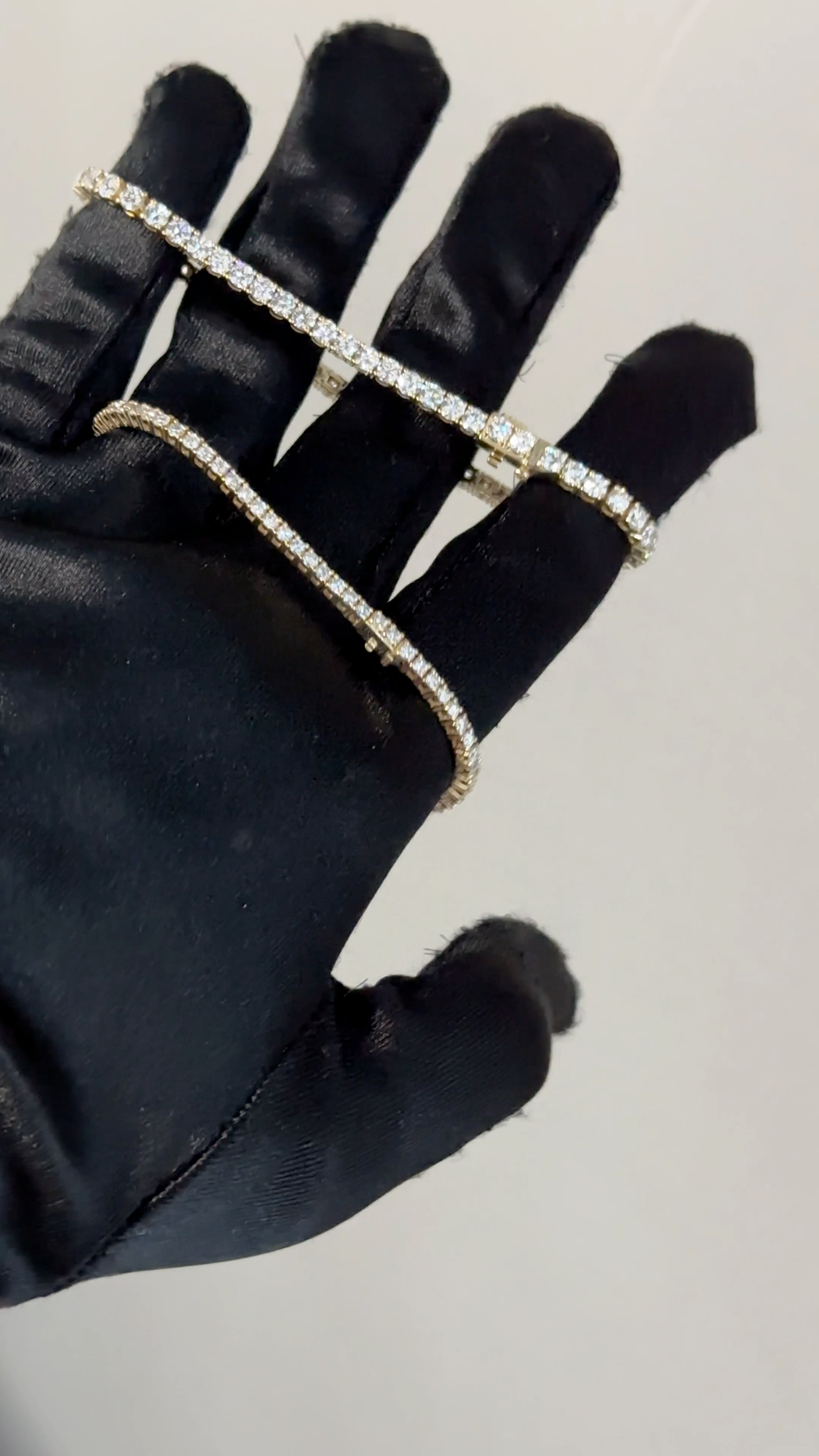 Two Eira Current tennis bracelets shown together on a black-gloved hand