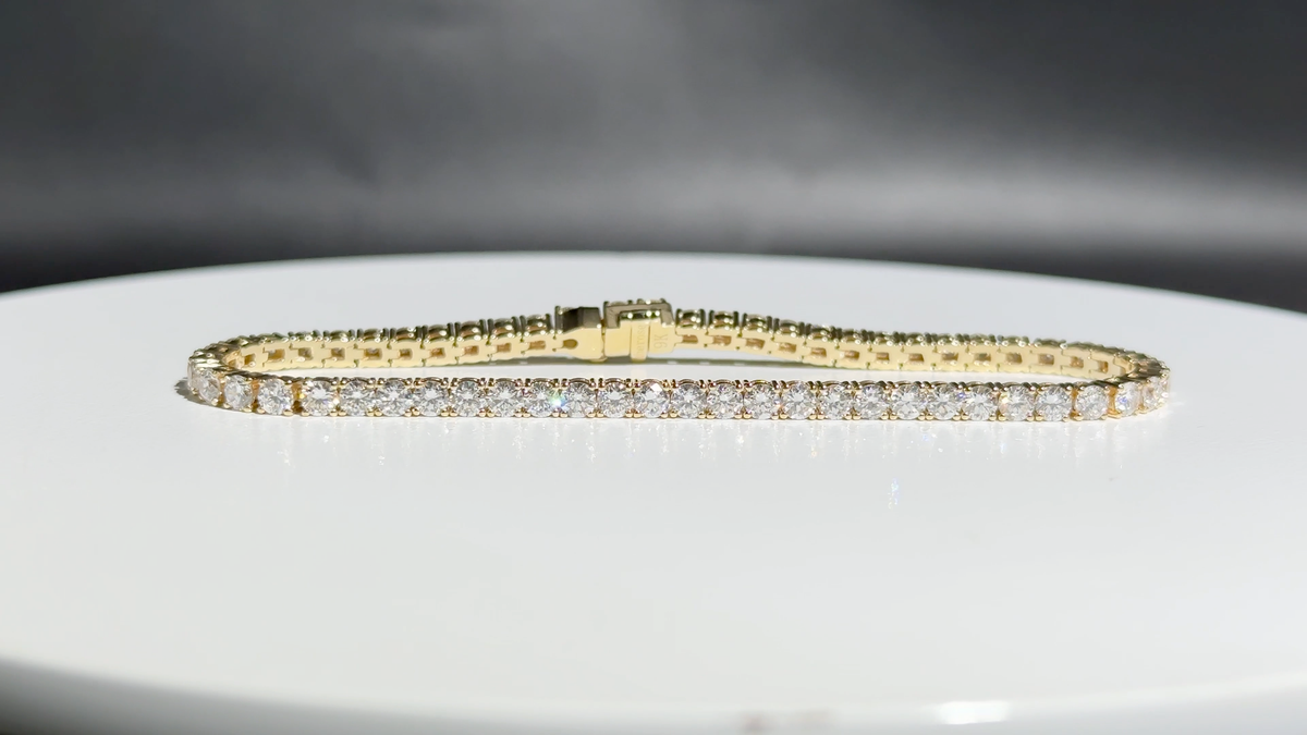 Eira Current tennis bracelet, front diamond line and clasp on a white turntable