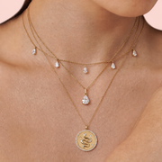 Aureline Crescent pear diamond necklace against a pale blush backdrop