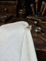 Isolde’s Secret ring on white jeweller’s linen at a traditional workbench, side view