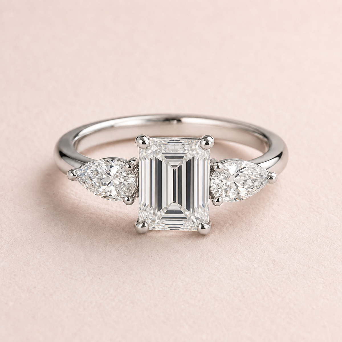 Lumera Passage three-stone ring concept with an emerald-cut centre and pear-shaped side stones in platinum