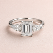 Lumera Passage three-stone ring concept with an emerald-cut centre and pear-shaped side stones in platinum