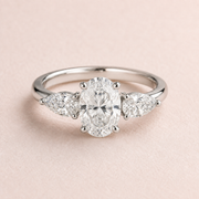 Lumera Passage three-stone ring concept with an oval-cut centre and pear-shaped side stones in platinum