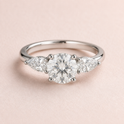 Lumera Passage three-stone ring concept with a round brilliant centre and pear-shaped side stones in platinum