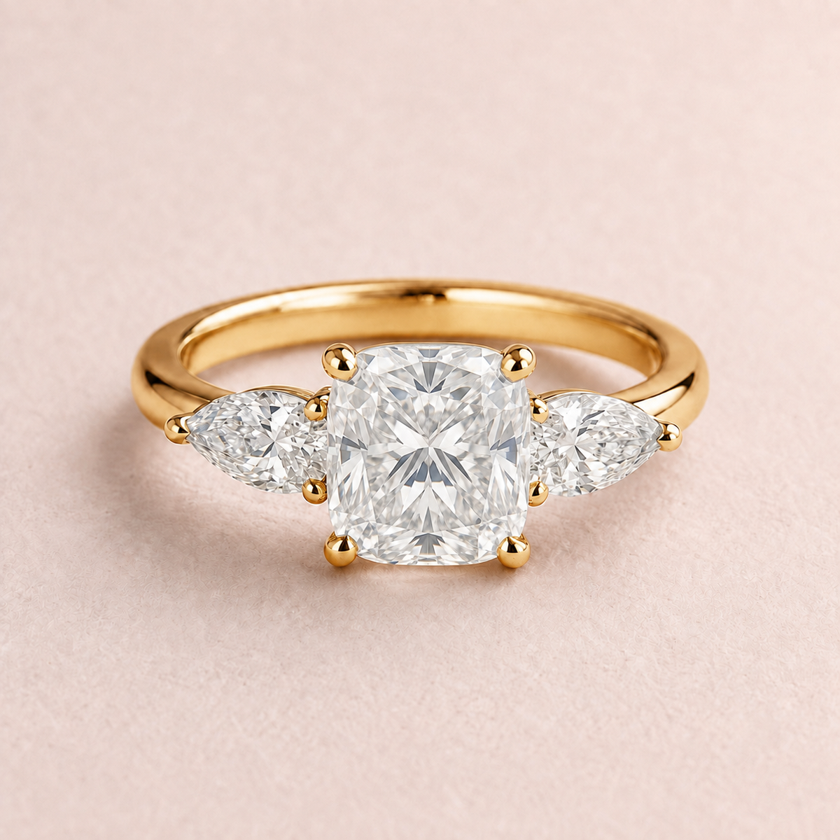 Lumera Passage three-stone ring concept with a cushion-cut centre and pear-shaped side stones in yellow gold