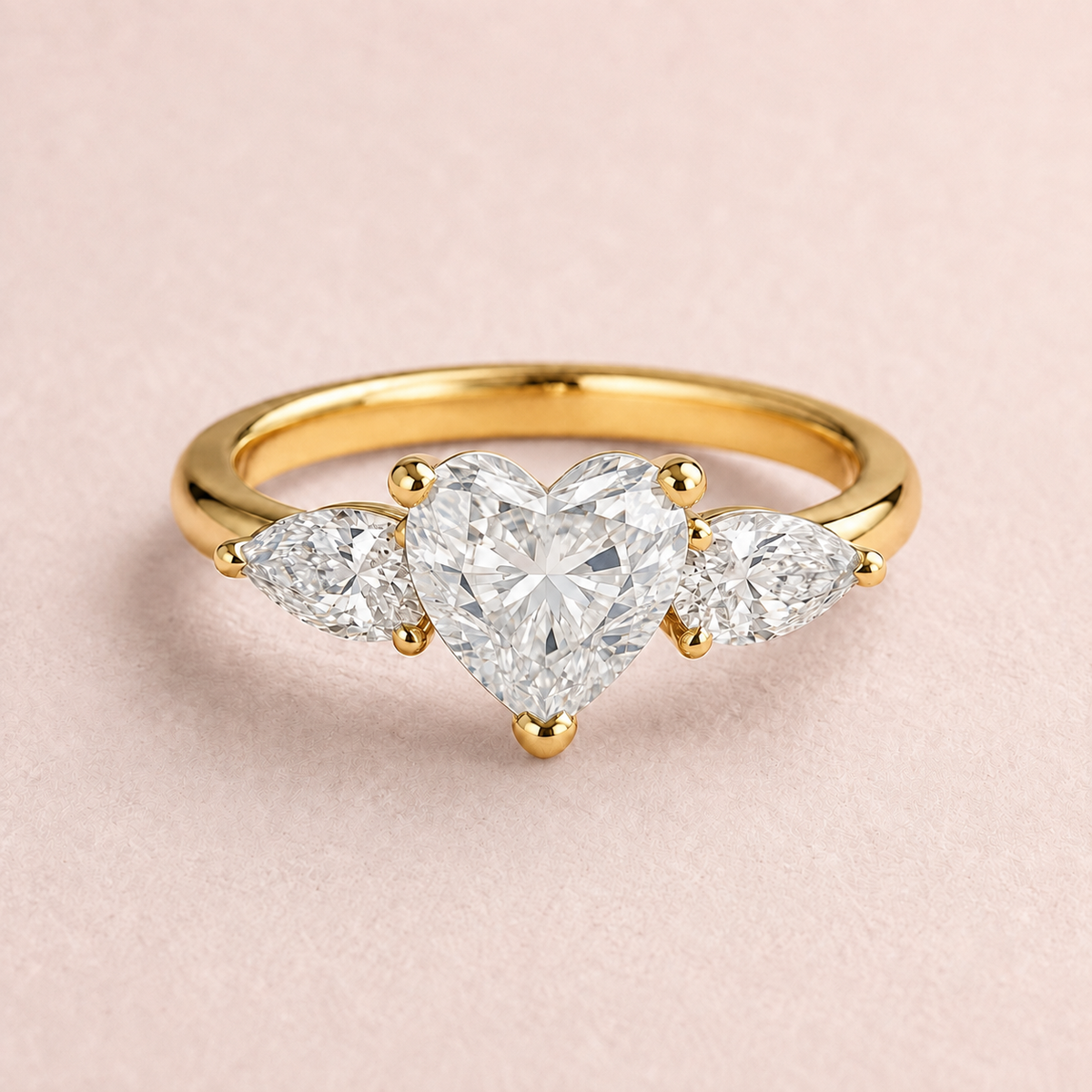 Lumera Passage three-stone ring concept with a heart-cut centre and pear-shaped side stones in yellow gold