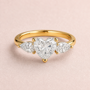 Lumera Passage three-stone ring concept with a heart-cut centre and pear-shaped side stones in yellow gold
