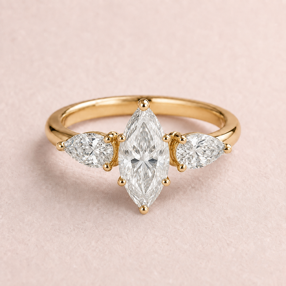 Lumera Passage three-stone ring concept with a marquise-cut centre and pear-shaped side stones in yellow gold