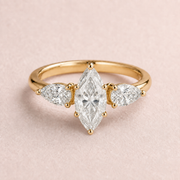 Lumera Passage three-stone ring concept with a marquise-cut centre and pear-shaped side stones in yellow gold