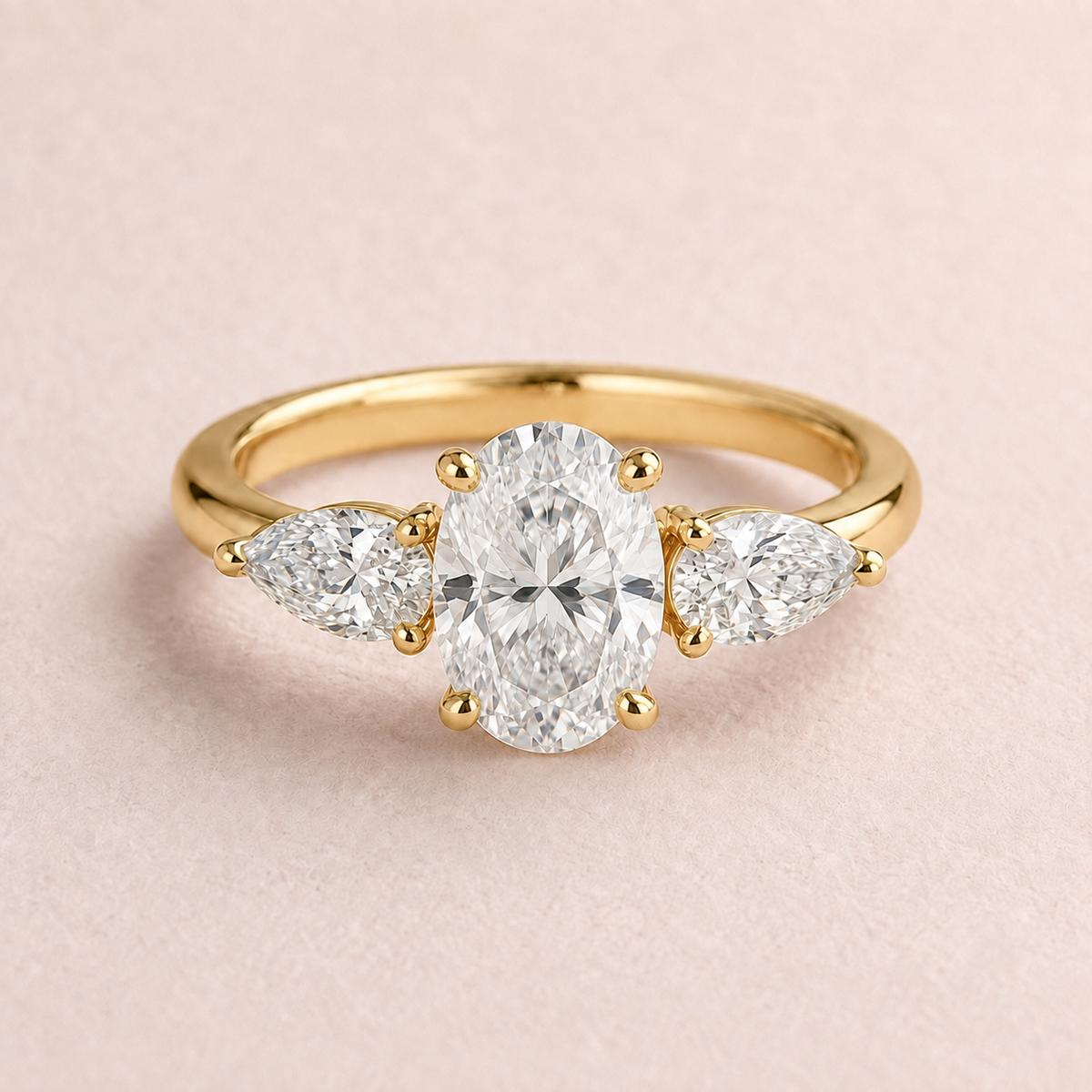 Lumera Passage three-stone ring concept with an oval-cut centre and pear-shaped side stones in yellow gold