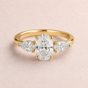 Lumera Passage three-stone ring concept with an oval-cut centre and pear-shaped side stones in yellow gold