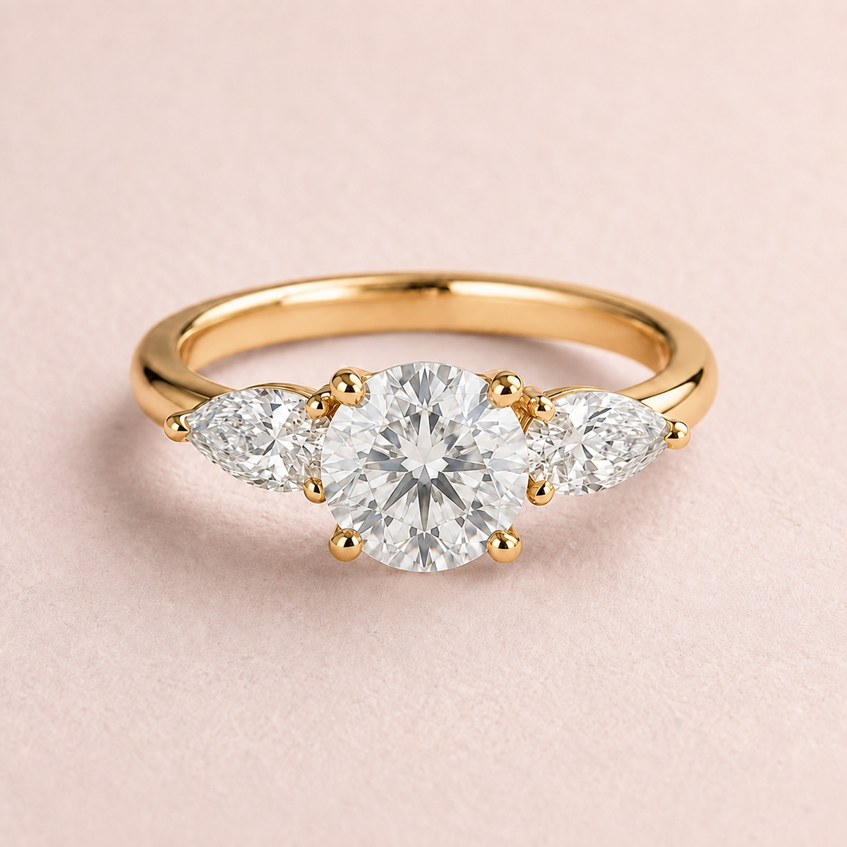 Lumera Passage three-stone ring concept with a round brilliant centre and pear-shaped side stones in yellow gold