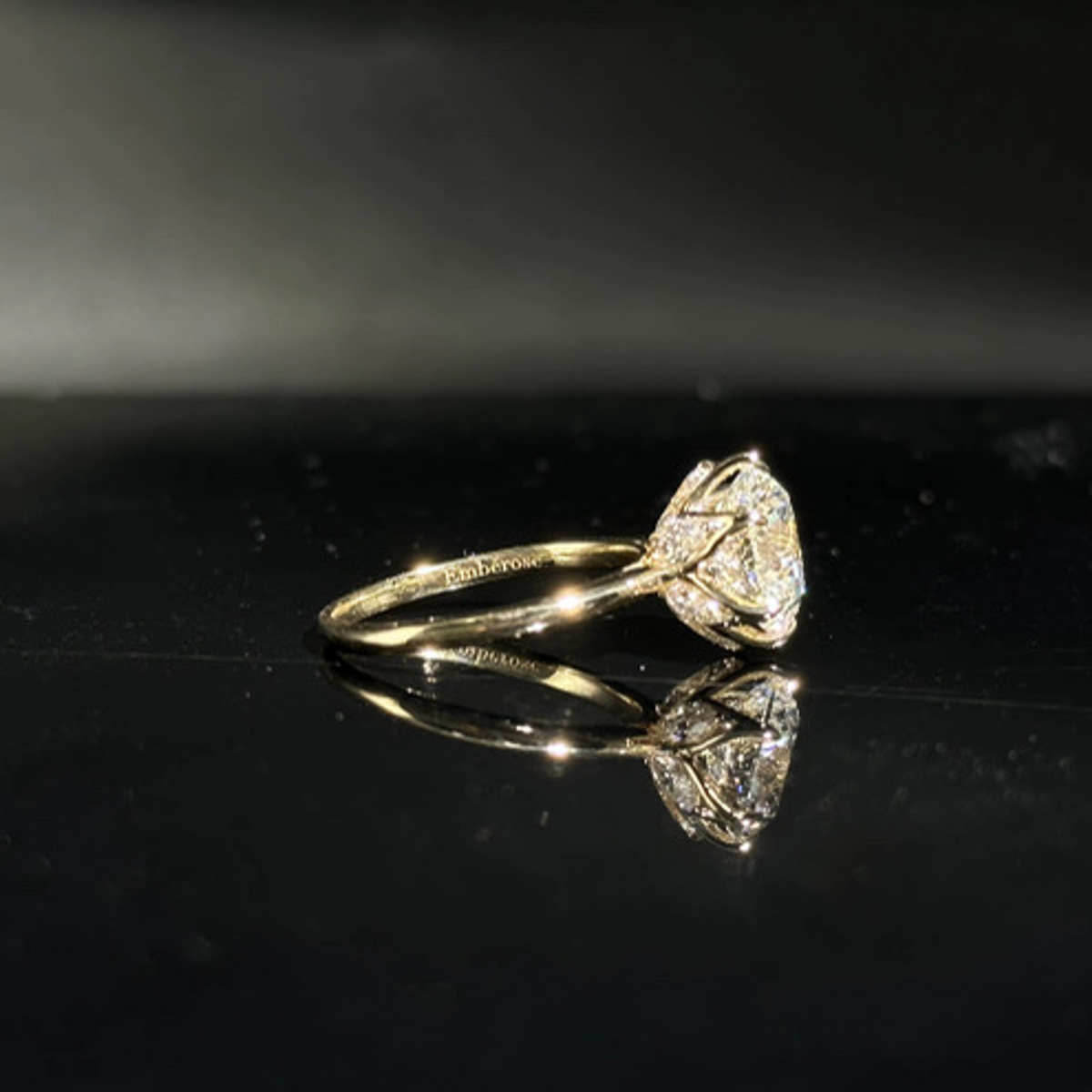 Olivia's Ovation lab-grown diamond ring in profile with its reflection on polished black Perspex