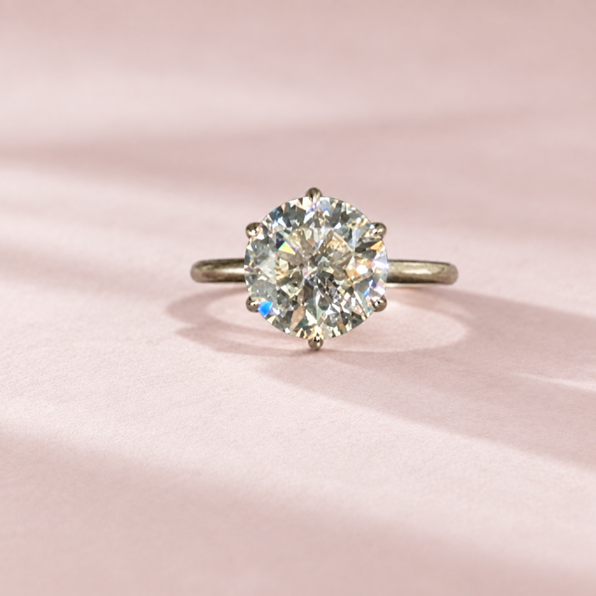 Olivia's Ovation round brilliant lab-grown diamond ring, centred front view on pale blush cotton paper