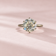 Olivia's Ovation round brilliant lab-grown diamond ring, centred front view on pale blush cotton paper