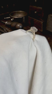Isolde's Secret elongated old-mine cushion engagement ring shown against a dark rustic jeweller's workbench