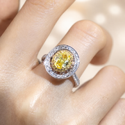 Sunlit Halo yellow diamond ring worn against a warm ivory background