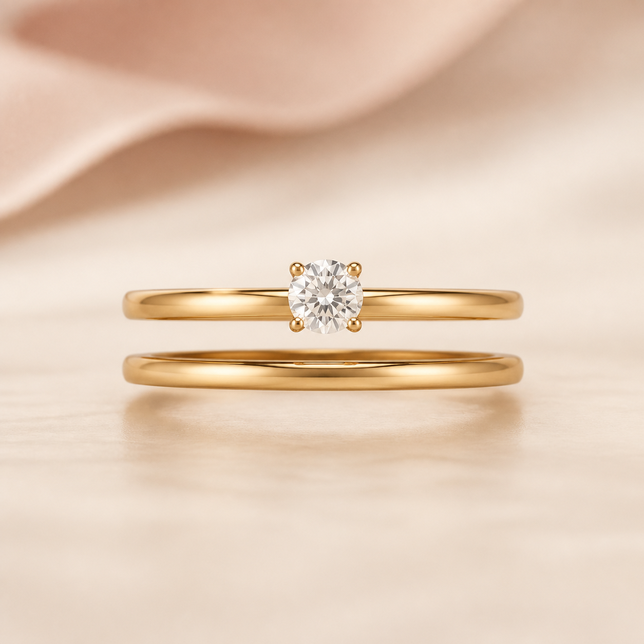 A yellow-gold wedding band held in a small intentional space beneath a solitaire engagement ring
